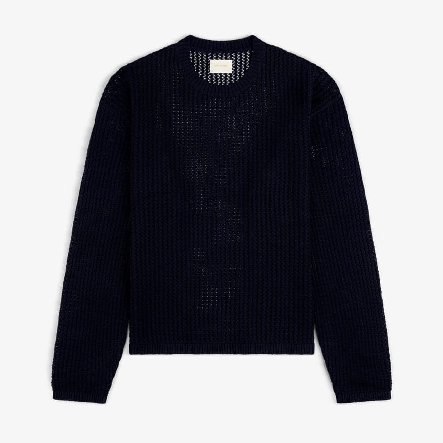 A navy open-knit crewneck sweater — a foundational layering piece in a 20s capsule