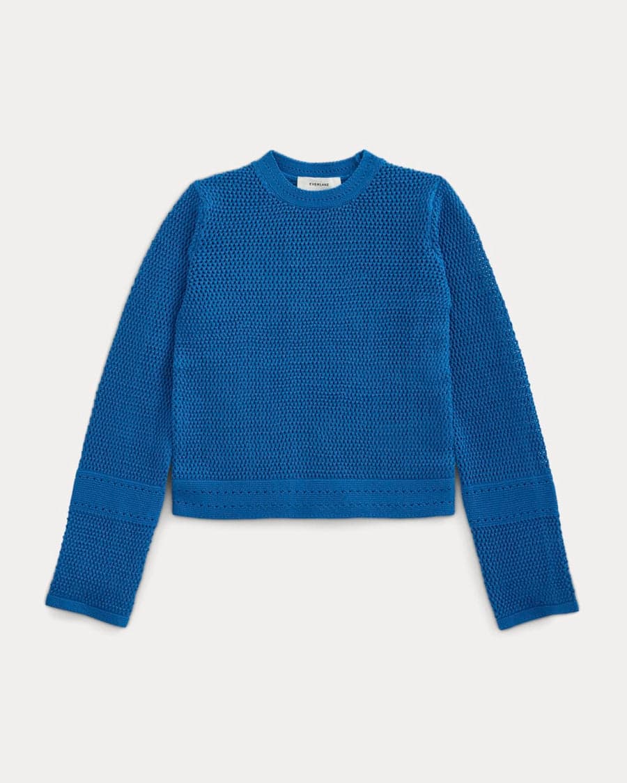 A blue open-knit crewneck sweater — a foundational layering piece for a 20s capsule